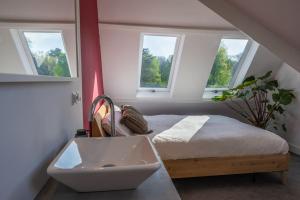a bedroom with a bed and three windows at Beautiful house close to Amsterdam Beach and Haarlem in Aerdenhout