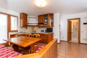 a kitchen with a wooden table and a dining room at Casa Alice in Falcade