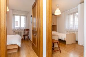 a small room with two beds and a door at Casa Alice in Falcade