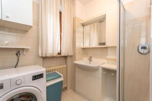 a small bathroom with a washing machine and a sink at Casa Alice in Falcade