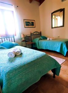 a bedroom with two beds and a mirror at Agriturismo Su Recreu in Ittiri