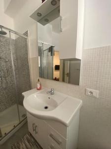 a white bathroom with a sink and a shower at Serradifalco Cozy House di Enza e Luigi in Palermo