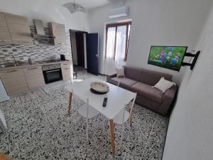 ein Wohnzimmer mit einem Sofa und einem Tisch in der Unterkunft La Corte Sarda Centro Storico a 5min di auto dal mare in Siniscola