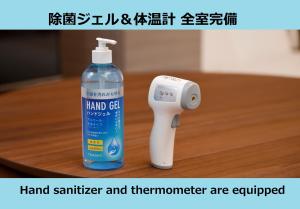 een fles handreiniger en thermometer zijn uitgerust bij スポルト東京 in Tokyo