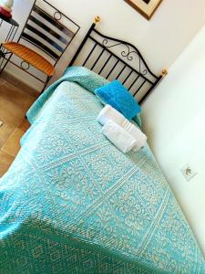 1 cama con manta azul y almohadas en Agriturismo Su Recreu, en Ittiri