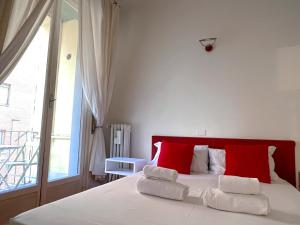 1 dormitorio con 1 cama con almohadas rojas y blancas en The Boutique Houses Milan - Repubblica - Central Station, en Milán
