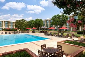 einen Pool in einem Hotel mit Tischen und Stühlen in der Unterkunft Washington Dulles Airport Marriott in Sterling