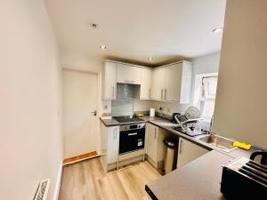eine Küche mit weißen Schränken und einer Arbeitsplatte in der Unterkunft Cosy private double ensuite room with free parking RG302RL in Reading