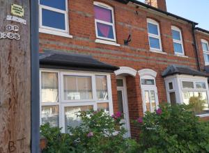 ein Backsteinhaus mit weißen Fenstern auf einer Straße in der Unterkunft Cosy private double ensuite room with free parking RG302RL in Reading