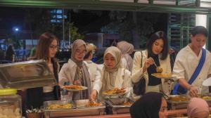 a group of people standing around eating food at The Win Hotel Surabaya in Surabaya