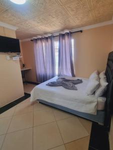 - une chambre avec un lit et des rideaux violets dans l'établissement Home Life Guesthouse, à Midrand