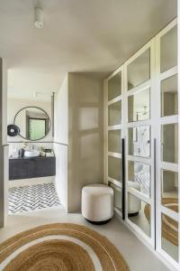 a bathroom with a stool and a sink and a mirror at LohonoStays Riyuvann Estate in Alibag