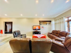 a living room with two leather couches and a table at Entire House in Beacon Bay - Family or Group Retreat - Swimming Pool - Multiple Braais in East London