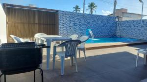 a patio with a table and chairs next to a swimming pool at Casa de praia com picina 2 in São José da Coroa Grande