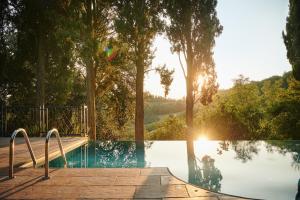 une piscine avec des arbres en arrière-plan dans l'établissement Villa Liverzano, à Brisighella