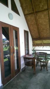 un porche con mesa, banco y mesa en Villa Paradise en Bukit Lawang