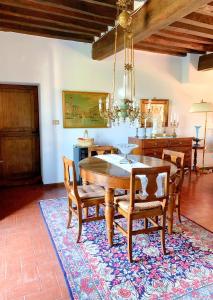 a dining room with a table and chairs on a rug at Casa Stella Country House in Savigno