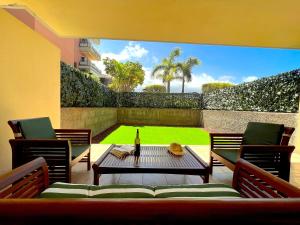 een patio met een tafel en stoelen en een fles wijn bij Tropicalidays Jardines del Teide in Puerto de la Cruz