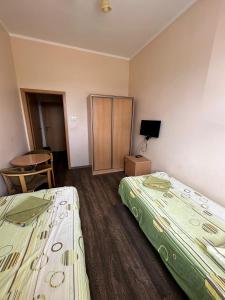 a hotel room with two beds and a chair at Hostel na Fali in Goleniów