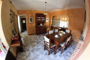 comedor y cocina con mesa y sillas en B&B Lo Scudiero, en Castelnuovo Don Bosco