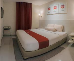 A bed or beds in a room at The Win Hotel Surabaya