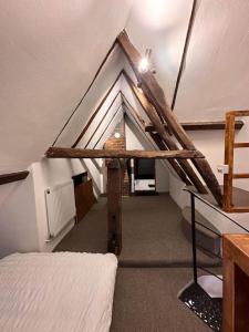 a attic room with a bed and a roof at The Signature 1360’s - Modern Apartment in Barnet