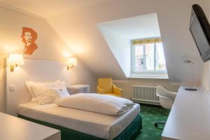 um quarto de hotel com uma cama e uma televisão em Hotel König Ludwig II em Garching bei München