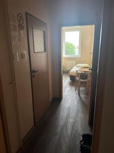 a room with a door and a table and a window at Hostel na Fali in Goleniów