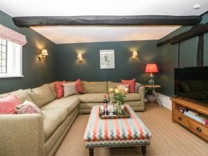 a living room with a couch and a tv at Lavender Cottage in Malvern Link