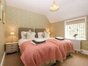 a bedroom with two beds and a window at Lavender Cottage in Malvern Link