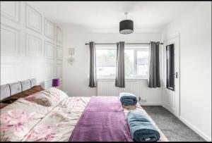 a bedroom with a bed with a purple blanket on it at Entire Immaculate 3 Bedrooms House in Blackburn Weekend Away in Blackburn