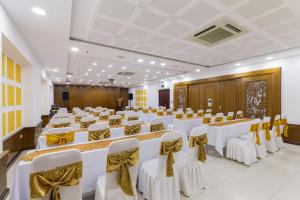 a conference room with white tables and chairs with bows at Star Hotel and Spa Danang in Danang