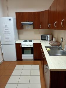 a kitchen with a white refrigerator and a sink at Hostel na Fali in Goleniów
