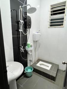 uma casa de banho com um chuveiro, um WC e um lavatório. em EMPIRE LUXURY HOMESTAY PAKA em Paka