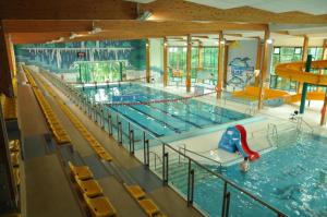 a large indoor swimming pool with a pool slide in it at Hostel na Fali in Goleniów