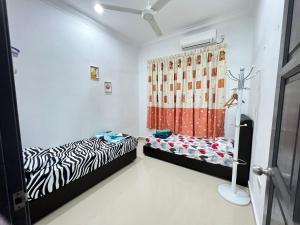 Cette chambre comprend 2 lits et un rideau. dans l'établissement EMPIRE LUXURY HOMESTAY PAKA, à Paka