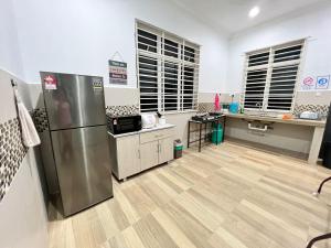 uma cozinha com um frigorífico de aço inoxidável num quarto em EMPIRE LUXURY HOMESTAY PAKA em Paka