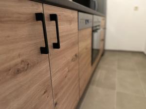 uma cozinha com armários de madeira com maçanetas pretas em Olaf und Hildegard em Bad Wildbad