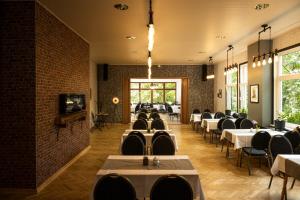 Hotel Mühlental في فيرنيغيروده: غرفة طعام مليئة بالطاولات والكراسي