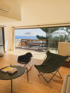 een woonkamer met een tafel en stoelen en uitzicht op de oceaan bij Cabanon moderne, les pieds dans l'eau in Le Pradet