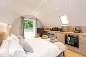 ein Schlafzimmer mit einem großen weißen Bett in einer Küche in der Unterkunft The Plough Inn Cabins in Ramsden