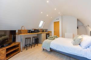 a bedroom with a bed and a kitchen with a counter at The Plough Inn Cabins in Ramsden