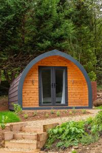 um pequeno barracão com uma porta num jardim em The Plough Inn Cabins em Ramsden