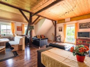 LudmannsdorfにあるSpacious Apartment in Lukowitz with Saunaの木製の天井とウッドフロアの広いリビングルーム