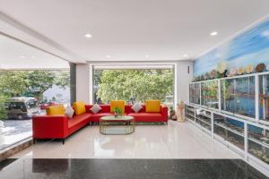 a living room with a red couch and yellow pillows at Star Hotel and Spa Danang in Danang