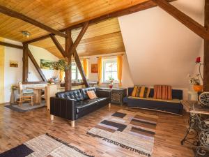 LudmannsdorfにあるSpacious Apartment in Lukowitz with Saunaのリビングルーム(黒革の家具、木製の天井付)