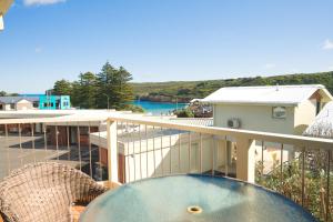 a balcony with a table and a view of the water at Loch Ard Motor Inn in Port Campbell