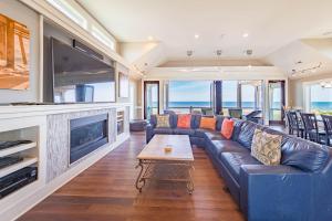 - un salon avec un canapé en cuir bleu et une télévision dans l'établissement Good Karma Retreat, à Nags Head