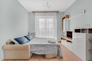 a white bedroom with a bed and a chair at FA 333 - Spacious apartment with views of Milan - in Milan