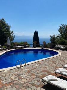 a large swimming pool in a yard with a stone patio at Maison Du Reve Scario in Scario